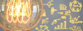 Close up of vintage glowing light bulb with business graph