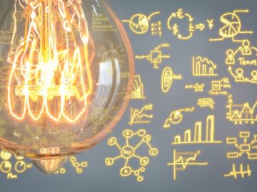 Close up of vintage glowing light bulb with business graph